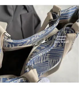 Detalle de la cremallera plateada suave y el tejido con patrón azul del bolso tote