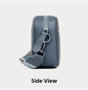 Side view of grey-blue pebble leather camera bag with wide geometric pattern strap