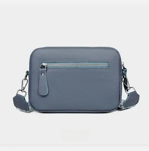 Detailed back view of navy blue pebbled leather camera bag with a functional zipper pocket