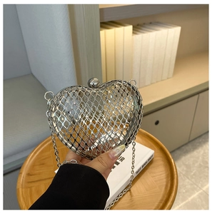 Detail of silver hollow heart-shaped evening clutch bag with metal chain strap