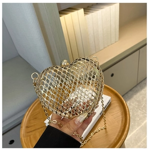 Detailed macro view of heart-shaped gold metal hollow evening bag with mesh texture