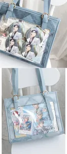 Detail of light blue denim ita bag with transparent PVC display window and metal buckles