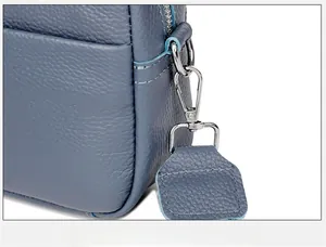 Detail of blue pebbled leather camera bag with polished silver metal hook and D-ring