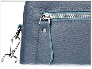 Detail of blue lychee leather camera bag featuring silver metal zipper and hardware