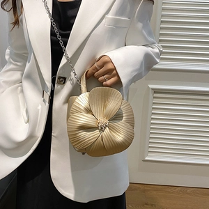 Metallic gold flower handbag with petal texture and chain strap shown on model