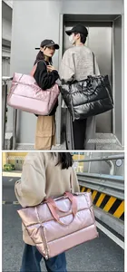 Sacs de voyage matelassés imperméables en rose et noir portés par des modèles