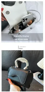 Detail of heart-shaped handbag with silver metal handle and smartphone storage capacity