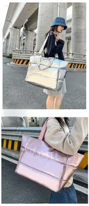 Détail de grands sacs de voyage matelassés métalliques en argent et rose pour sport
