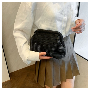Detail of black rhinestone evening bag showing sparkling textured surface and round shape