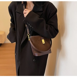 Detail of vintage dark brown suede and leather bucket bag with gold metal lock buckle