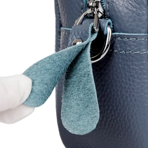 Detail of high-quality navy blue genuine leather camera bag with litchi grain and zipper puller