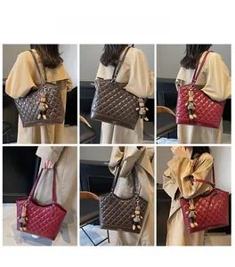Quilted faux leather bucket bag detail featuring metal ring hardware and plush rabbit charm