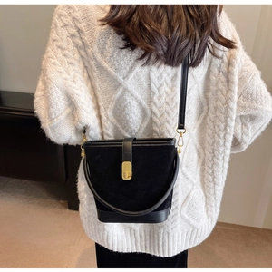 Black bucket bag with vintage gold twist lock shown worn on model for size perspective