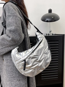 Quilted silver crescent shoulder bag with metallic finish and adjustable black strap
