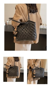 Detail view of black quilted tote bag with cute rabbit pendant and FASHION BAG text