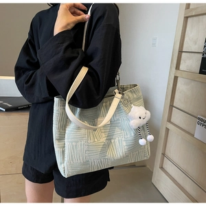Detalle del bolso tote de jacquard verde claro con colgante de nube y textura