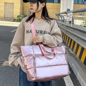 Grand sac de voyage matelassé rose avec bandoulière réglable et finition métallisée