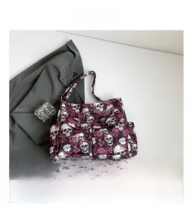 Detail of canvas tote bag featuring red roses and skull print with multiple pockets