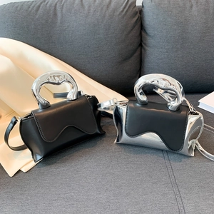 Designer heart-shaped bags in black and silver with unique industrial metal handles