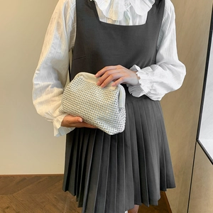 Sparkly silver rhinestone cloud clutch bag held by a model with elegant pleated skirt