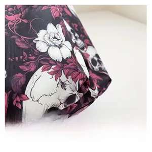 Close-up of durable canvas fabric with white skull and dark red rose floral print