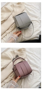 Detail von geflochtenen Eimertaschen in Grau und Lila mit Silberketten und Metallfüßen