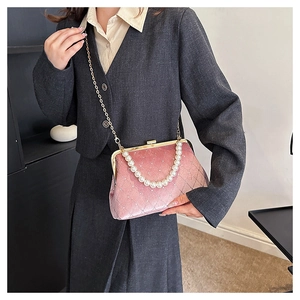Close-up of pink velvet quilted shell bag with pearl handle and golden chain strap