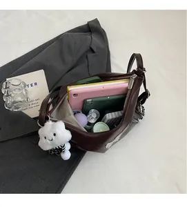 Spacious interior of a dark brown leather tote bag holding a tablet and daily items