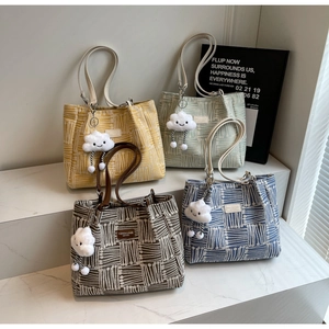 Detalle de cuatro bolsos tote de lona coloridos con patrones geométricos y colgantes