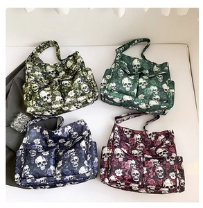 Detail view of four skull and floral print canvas tote bags with front pockets