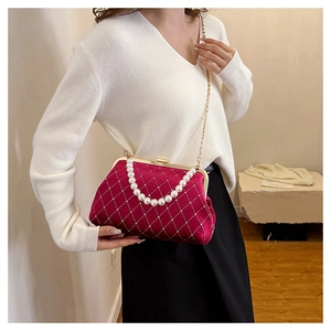 Detail of velvet shell bag with white pearls, diamond lattice pattern and chain strap
