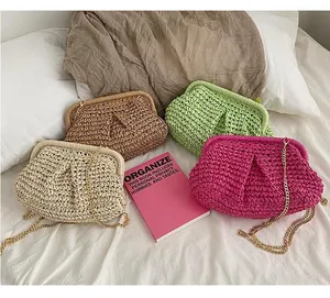 Detail of woven straw cloud bags in four colors with gold metal chains for summer