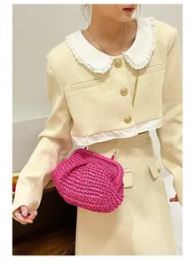 Detail of fuchsia woven crossbody bag with gold chain worn on cream tweed outfit