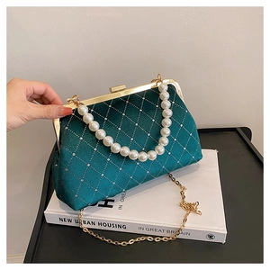 Detail of emerald velvet shell bag with rhinestone quilt and pearl handle