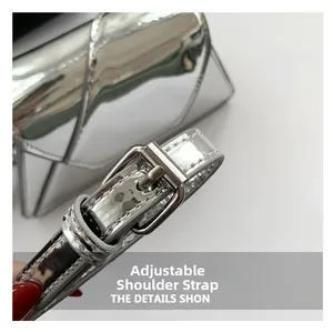 Detail view of adjustable silver patent leather strap with metallic buckle on handbag