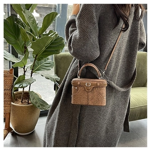 Detail view of a vintage box bag featuring unique denim pocket design and cork texture
