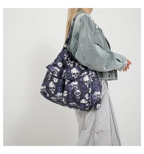 Detail of canvas tote bag featuring skull and purple rose print with a front pocket