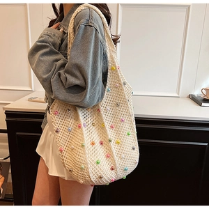 Detail of hand-woven shoulder tote bag with colorful pearl accents and crochet texture