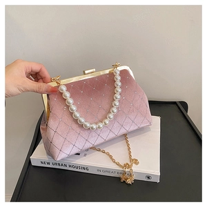 Detailed view of pink velvet shell bag with quilted texture and elegant pearl handle