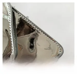 Close-up of silver patent leather shoulder bag with metallic finish and fine stitching