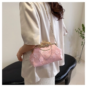 Close-up of pink floral embroidery and sequins on lace evening bag with gold clasp