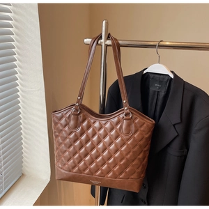 Braune Stepp-Tote-Bag mit doppelten Trägern und Fashion-Schriftzug im Büro-Ambiente