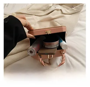 Internal storage view of a pink box handbag with phone and cosmetic accessories