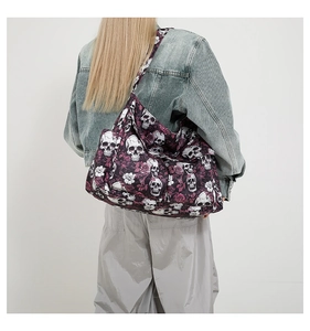 Detail of a large canvas shoulder bag featuring white skull and purple rose patterns