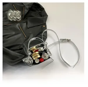 Detail view showing interior capacity of a silver metallic mini handbag with cosmetics