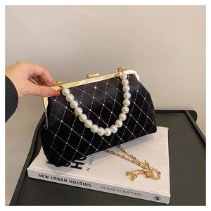 Detail of velvet shell bag featuring pearl handle and rhinestone diamond pattern