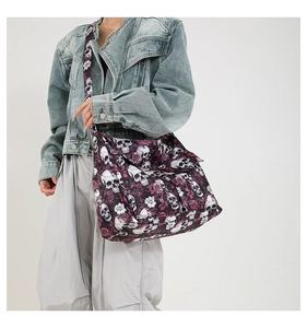 Detail of canvas messenger bag with purple skull and rose print and wide shoulder strap