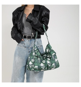 Detail of canvas shoulder bag featuring green skull and rose floral print pattern