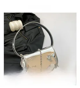Close-up of shiny silver patent leather handbag with a metallic bead chain strap
