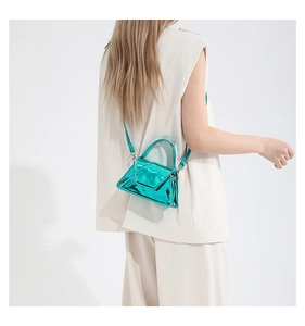 Model wearing a bright metallic green patent leather crossbody bag with chain strap detail